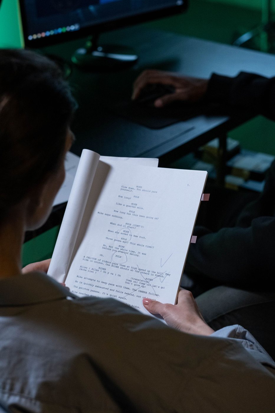 A reader examines a script with handwritten annotations.
