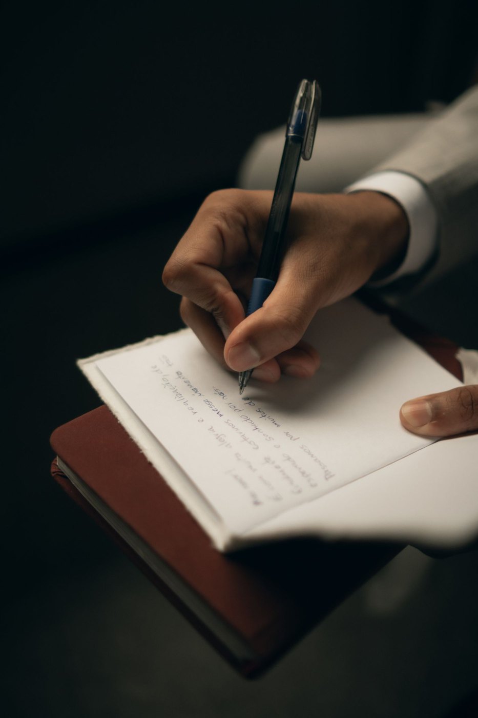 A pen held over a handwritten journal page.