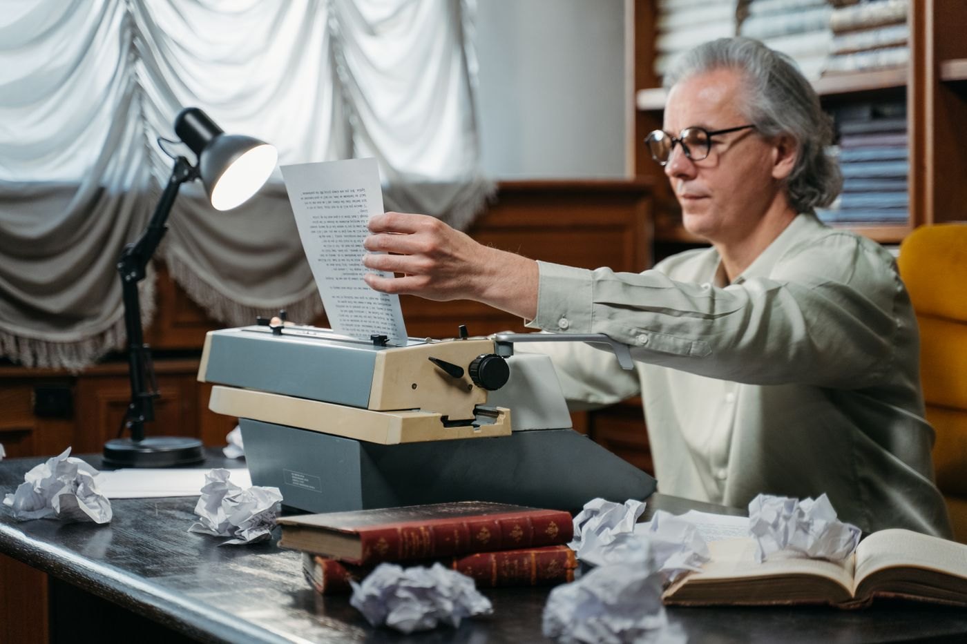 A writer removes a typed page from a typewriter.