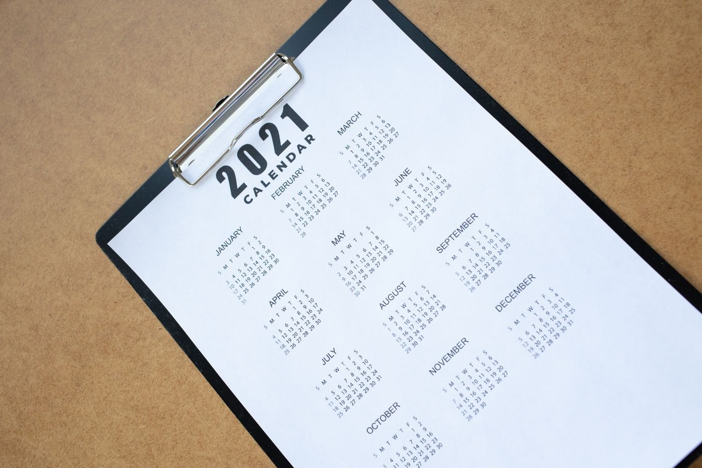 A calendar page clipped to a board on a desk.