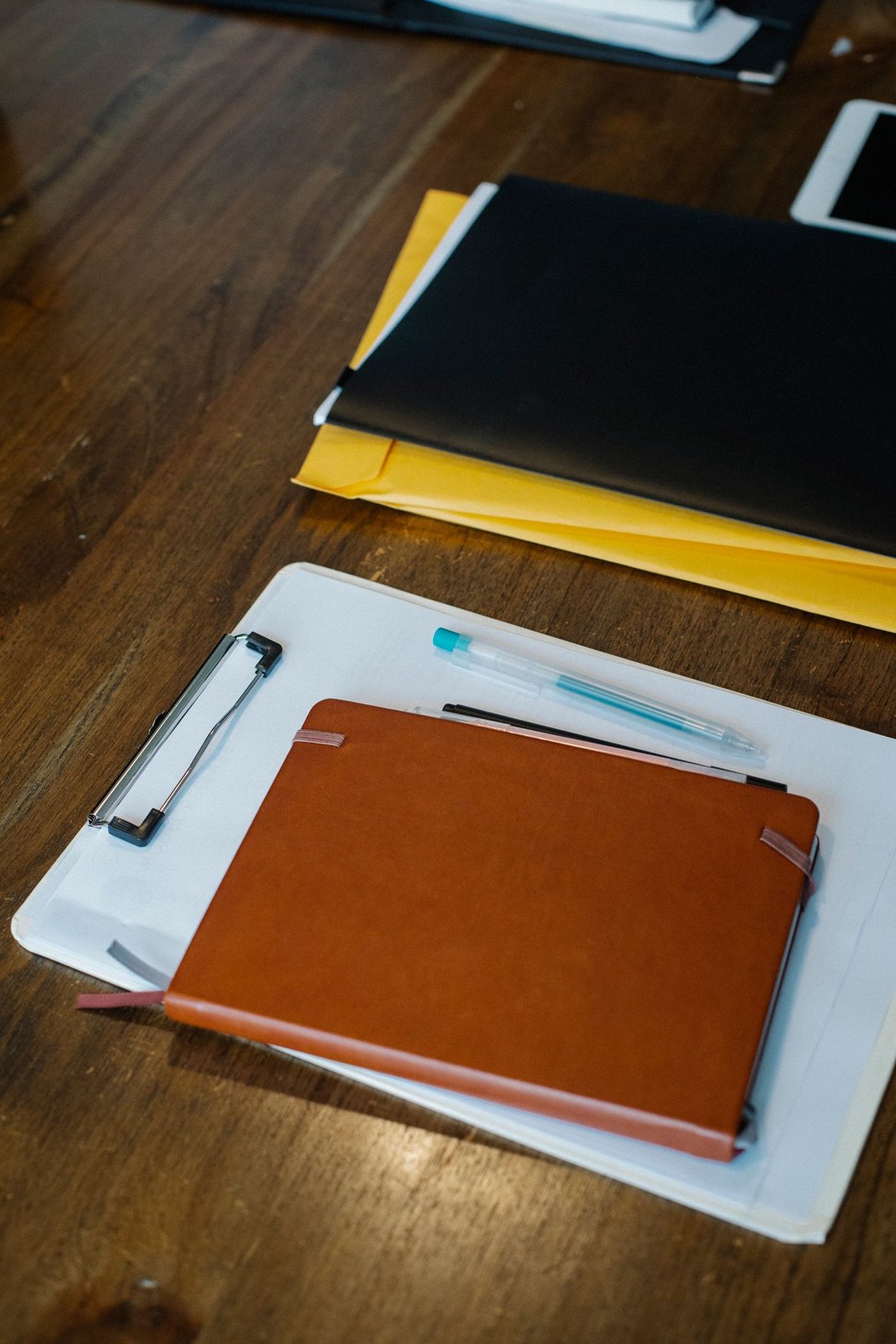 Clipboard, notebooks and folders arranged for a document handover