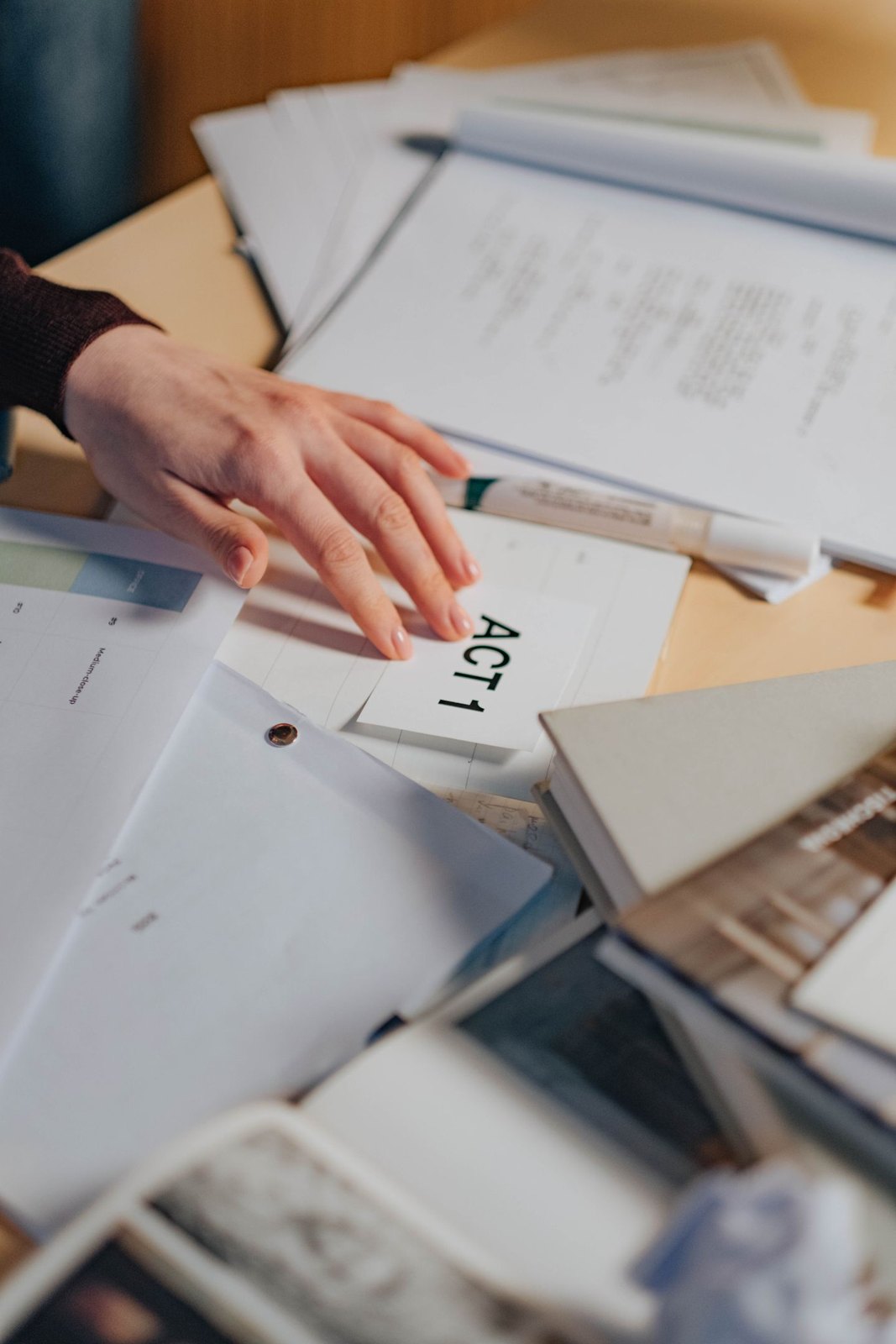 Hands arranging the pages of a script