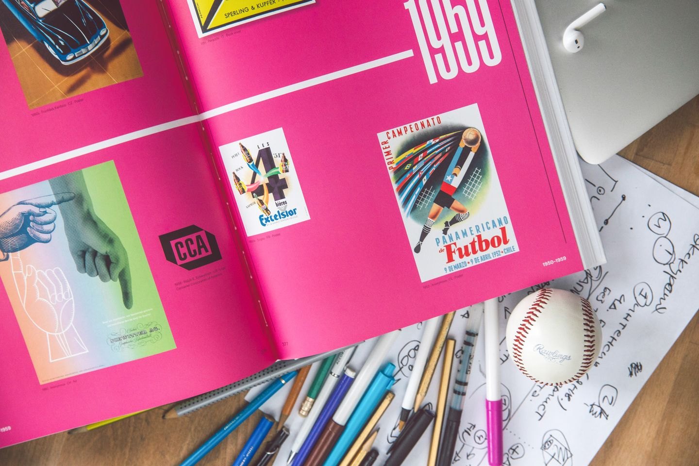 Graphic-design book open beside sketches and pencils