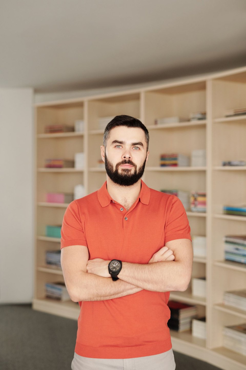 A portrait of a man standing in front of bookshelves.