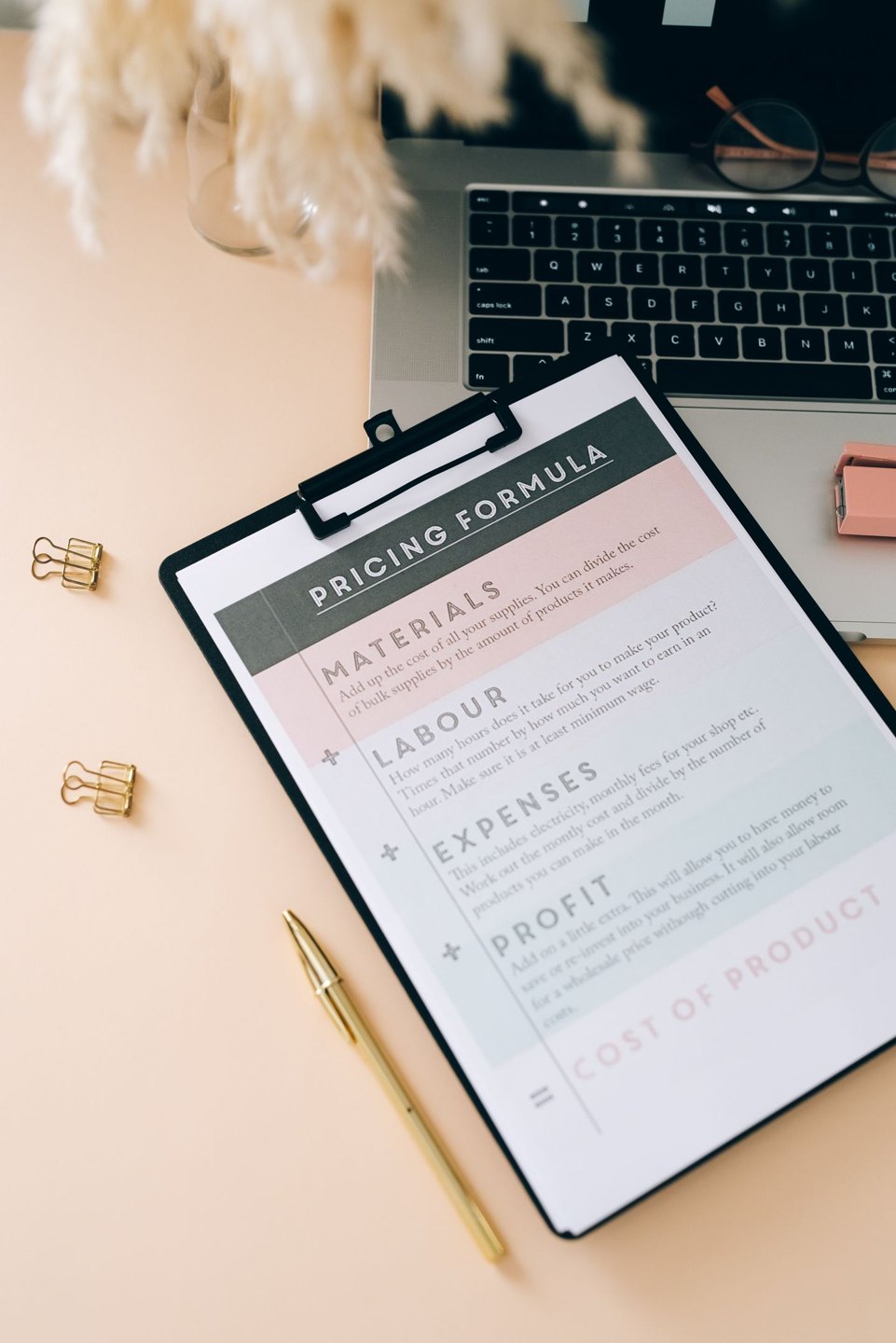 A budget-planning document on a clipboard beside a laptop.