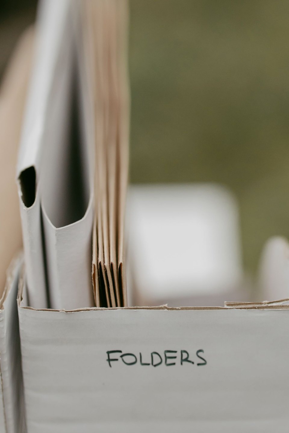 Paper folders arranged in a labelled storage box.